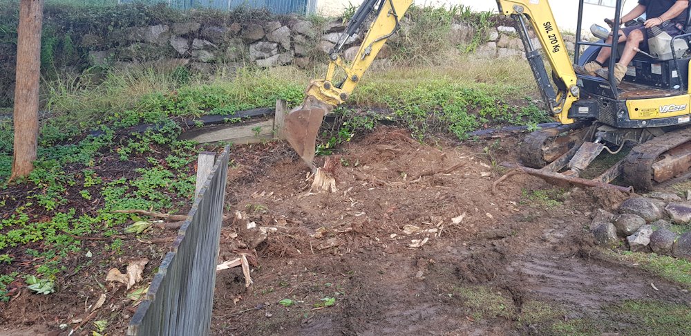 Work begins on deconstructing the old block retaining wall.